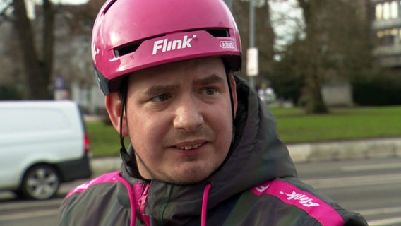 Ein Fahrradfahrer wird auf der Straße interviewt. © NDR 