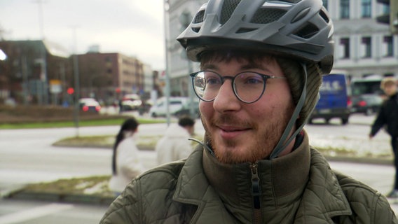 Ein Fahrradfahrer wird auf der Straße interviewt. © NDR 