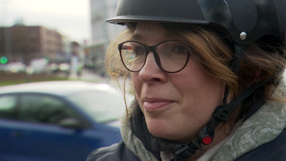 Eine Fahrradfahrerin wird auf der Straße interviewt. © NDR 