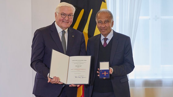 Klimaforscher Prof. Dr. Mojib Latif steht neben dem Bundespräsidenten Frank-Walter Steinmeier und präsentiert seinen Verdienstorden. © dpa Foto: Joerg Carstensen