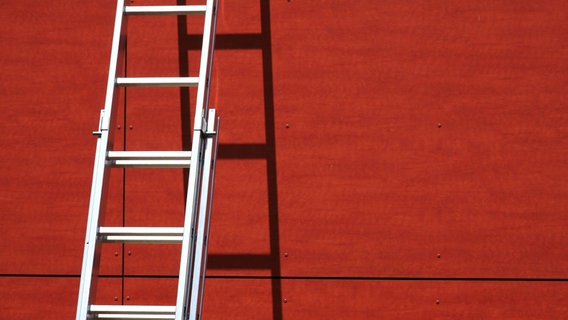 Eine Leiter lehnt an einer roten Hauswand © Imago Images / Zoonar Foto: Imago Images / Zoonar