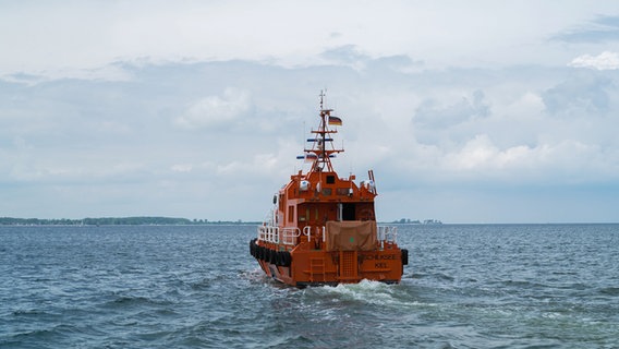 Ein orangenes Lotsenboot läuft gerade aus in die Kieler Förde. © NDR Foto: Dominik Dührsen