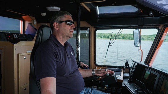 Der Lotsenbootführer sitzt am Steuer des Bootes. © NDR Foto: Dominik Dührsen