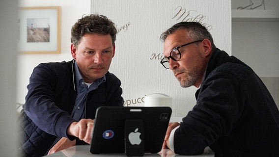 Zwei Männer sitzen vor einem Tablet, der linke scrollt. © NDR Foto: Dominik Dührsen