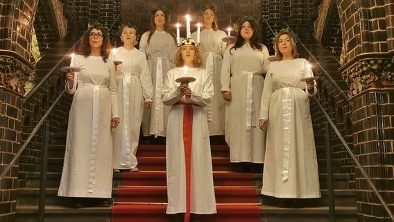 Mehrere Frauen auf einer Treppe mit Kerzen © Hansestadt Lübeck Foto: Hansestadt Lübeck