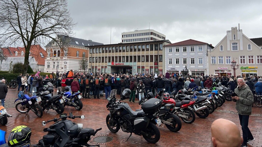Auf dem Marktplatz in Heide ist eine große Menschenmenge zusammengekommen. Im Vordergrund sind mehrere Motorräder.