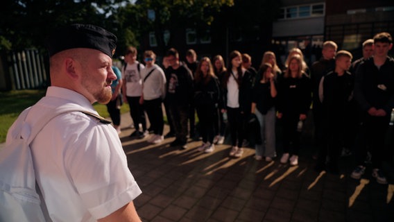 Eine Schulklasse steht vor einem Soldaten der deutschen Marine © NDR Foto: NDR Screenshot