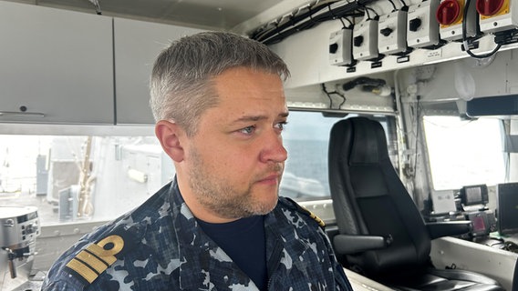 Ein Mann in einem Overall der Marine auf der Brücke eines Schiffes © NDR Foto: Andreas Schmidt