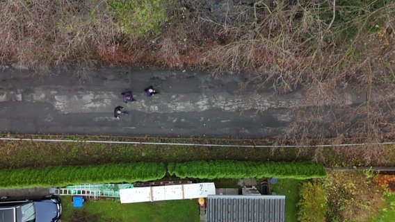 Eine Aufnahme aus der Vogelperspektive von Menschen, die eine Straße entlang gehen © NDR Foto: NDR Screenshot