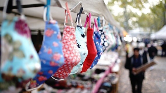 Mouth and nose covers are offered at a stand at a weekly market.  © Kay Nietfeld / dpa Photo: Kay Nietfeld