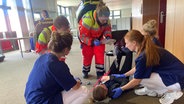 Rettungspersonal kümmert sich während einer Übung um eine verletzte Person © NDR Foto: Christiane Stauss