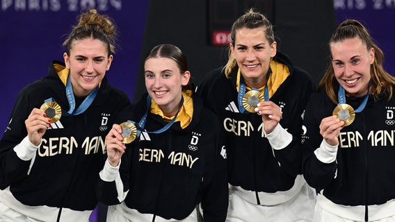 Marie Reichert (l-r), Elisa Mevius, Sonja Greinacher und Svenja Brunckhorst jubeln bei der Siegerehrung von Olympia in Paris. © picture alliance/dpa Foto: Sina Schuldt