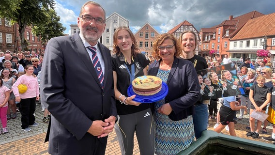 Mehrere Personen posieren für ein Gruppenbild auf dem Rathausmarkt von Rendsburg © NDR Foto: Lisa Synowski