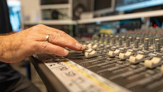 Eine Hand an einem Mischpult mit vielen Knöpfen. © NDR Foto: Dominik Dührsen