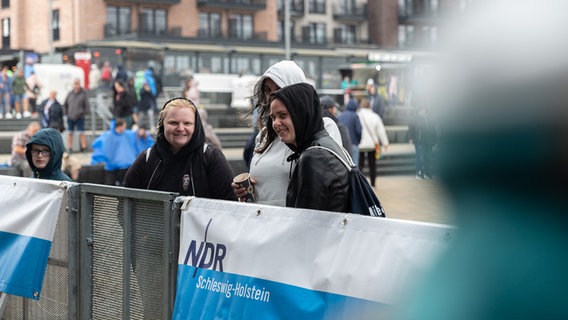 Drei junge Frauen stehen in der ersten Reihe vor eine Bühne. © NDR Foto: Dominik Dührsen