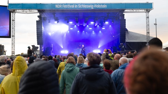 Viele Menschen stehen vor einer Bühne und lauschen einem Konzert. © NDR Foto: Dominik Dührsen