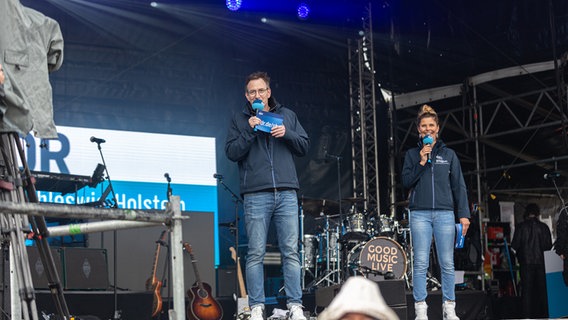 Ein Mann und eine Frau stehen auf einer Bühne und haben Mikrofone in der Hand. © NDR Foto: Dominik Dührsen