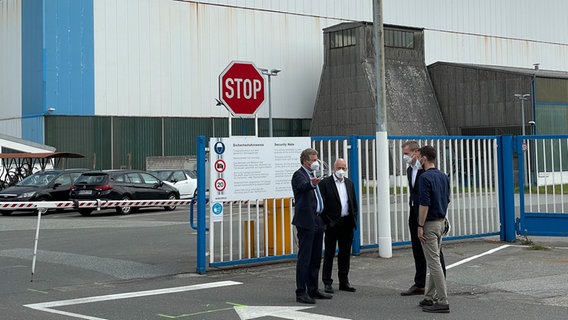 Eine Gruppe von Männern unterhält sich vor dem Gebäude der Nobiskrug GmbH © NDR Foto: Christian Wolf