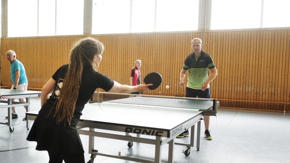 Karsten Polle spielt mit Britta Freimuth Tischtennis in einer Sporthalle. © NDR Foto: Lisa Pandelaki