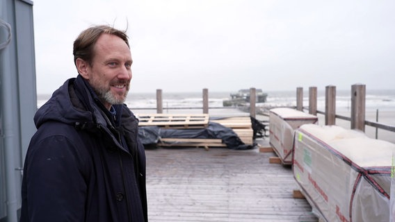 Roland Pape, Projektleiter steht auf Terrasse der neuen Strandbar "54 Grad Nord" in St. Peter Ording. © NDR 