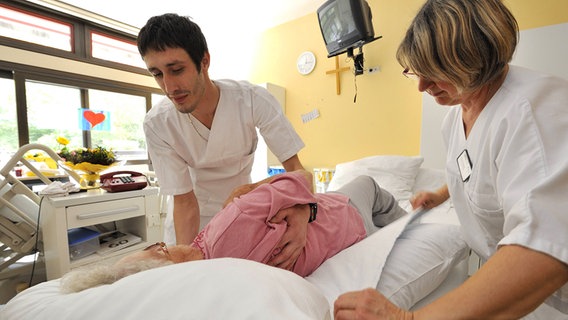 Pfleger bei der Arbeit mit einer Patientin. © Imago 
