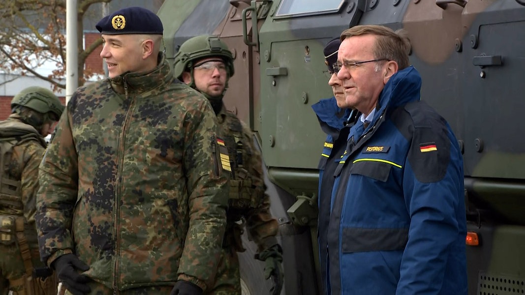 Verteidigungsminister Boris Pistorius (SPD) steht neben Marineoffizieren beim Ankunft auf dem Marinestützpunkt in Eckernförde.