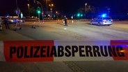 Hinter einem Absperrband stehen mehrere Polizisten an einem Unfallort auf einer Kreuzung. © Hansi Kahts Foto: Hansi Kahts