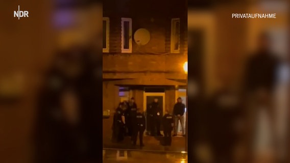 Auf einem Hochkant-Handyvideo ist eine Einsatzmannschaft der Polizei vor einem Hauseingang zu sehen © privat Foto: privat