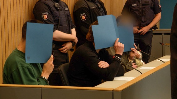 Vier Angeklagte stehen vor dem Lübecker Landgericht. © NDR 