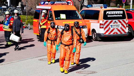 Kiel: Einsatzkräfte der Feuerwehr bereiten sich in Schutzanzügen auf die Untersuchung eines unbekannten Stoffes vor. © dpa Foto: Frank Molter