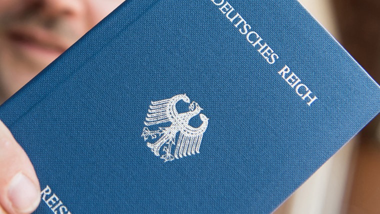Ein Mann hält ein Heft mit dem Aufdruck "Deutsches Reich Reisepass" in der Hand. © dpa-Bildfunk Foto: Patrick Seeger