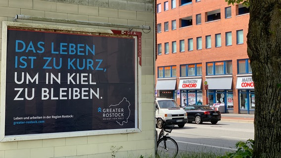 Auf einem Plakat steht: "Das leben ist zu kurz, um in Kiel zu bleiben" © NDR Foto: Stella Kennedy
