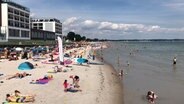 Zahlreiche Menschen tummeln sich an einem Badestrand in Scharbeutz. Foto: Hauke Bülow