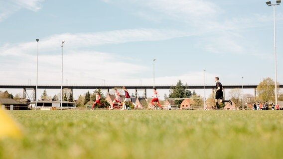 Fußballspieler und Schiedsrichter laufen während des Spiels über das Feld. © NDR Foto: Lisa Pandelaki