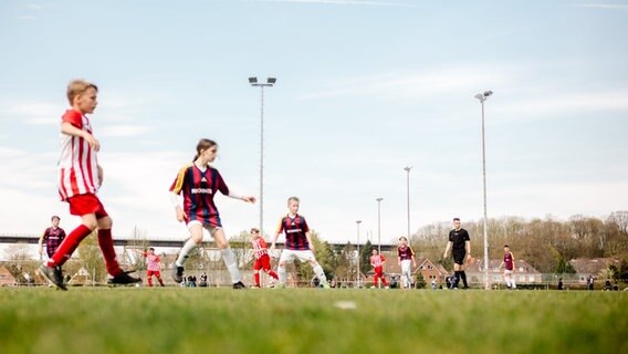 Fußballspieler und Schiedsrichter laufen während des Spiels über das Feld. © NDR Foto: Lisa Pandelaki