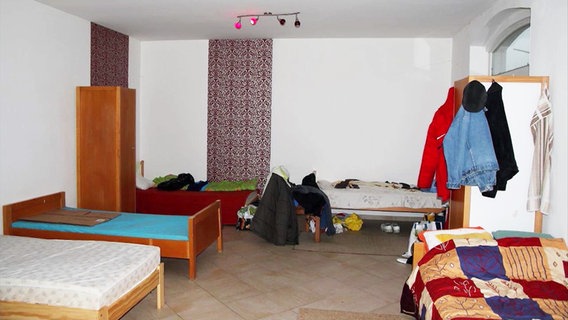 Ein schäbiges Zimmer mit fünf Betten dient Mitarbeitern eines Schlachtbetriebes als Unterkunft. © NDR 