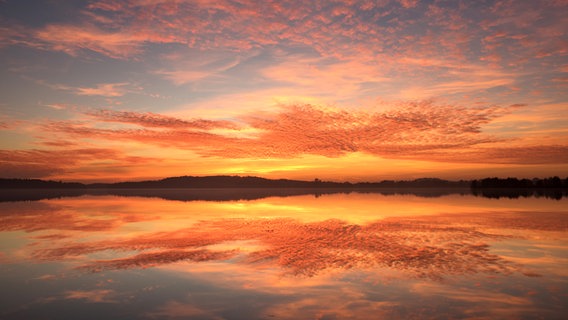 Die Spiegelung des Sonnenuntergangs im Plöner See. © Gunnar Asmus Foto: Gunnar Asmus