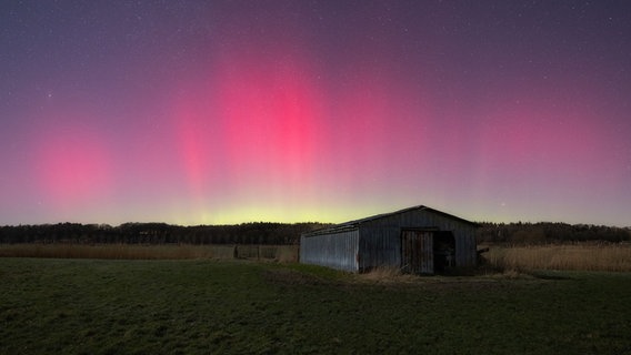 Nachtlichter leuchten am Himmel über einem Feld mit einer Scheune. © Mark Kruse Foto: Mark Kruse