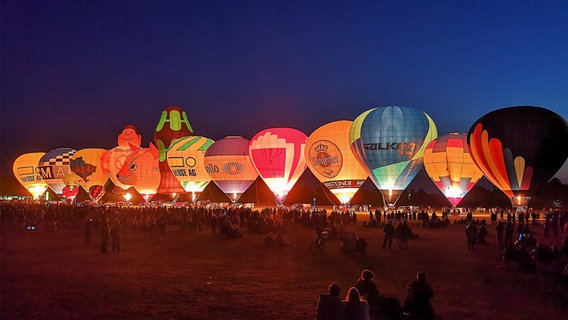 Mehrere Heißluftballons nebeneinander auf einem Feld. © Birte Schneck Foto: Birte Schneck