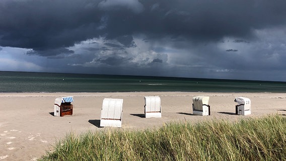Strand mit Strandkörben und Regen im Hintergrund. © Holger Oehler Foto: Holger Oehler