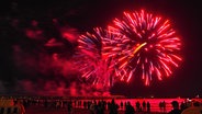 Ein rot leuchtendes Feuerwerk erstrahlt über der neuen Seebrücke am Timmendorfer Strand. © Hans-Otto Klies Foto: Hans-Otto Klies