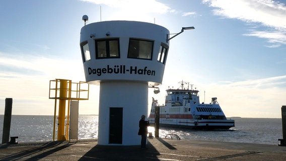 Eine Fähre fährt im Sonnenuntergang am Pegelturm in Dagebüll vorbei. © Cordula Sönnichsen Foto: Cordula Sönnichsen