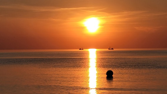 Durch die leuchtende Abendsonne erscheinen die Silhouetten der Boote. © Holger Totzek Foto: Holger Totzek