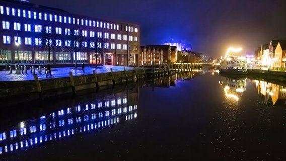 Der Husumer Hafen bei Nacht, mit hellerleuchteten Fenstern des Rathauses. © Rolf Brückner Foto: Rolf Brückner