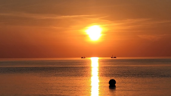 Die untergehende Sonne spiegelt sich im Wasser bei St. Peter-Ording © Holger Totzek Foto: Holger Totzek