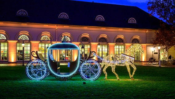 Eine leuchtende Pferdefigur zieht vor dem Eutiner Schloss eine Kutsche. © Axel Bärendorf Foto: Axel Bärendorf