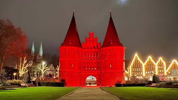 Das Holstentor bei Abend, winterlich-rot angeleuchtet. © Sabine Schöne Foto: Sabine Schöne