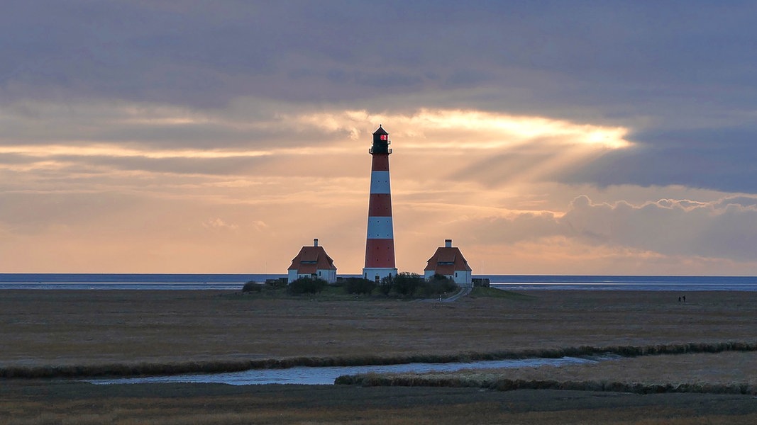 Der Westerhever Leuchtturm steht im Licht der untergehenden Sonne.