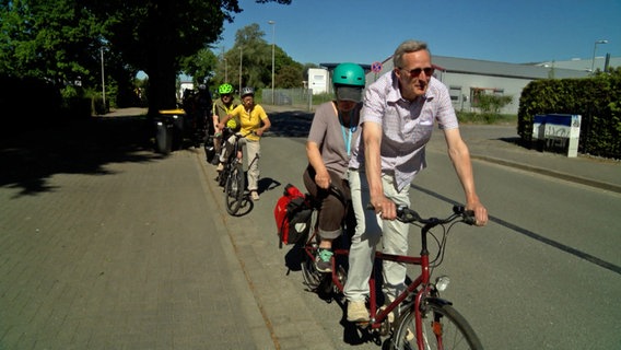 Mehrere Tandemfahrer beginnen am Straßenrand eine Radtour © NDR Foto: NDR Screenshot