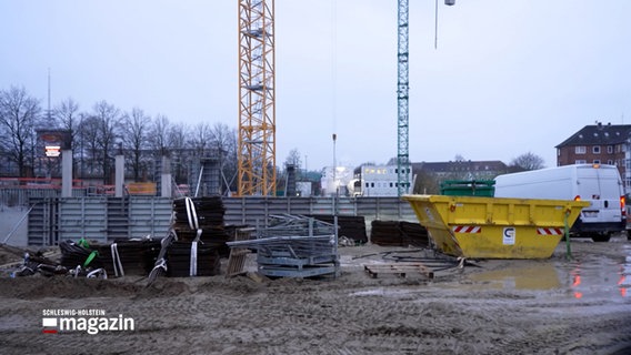 Im verregneten Kiel auf einer Baustelle stehen Kräne, Container und Materialien. © NDR 